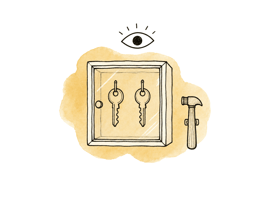 Two keys sit inside a protected emergency box with a small hammer and monitoring eye above it.